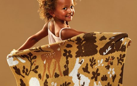 little girl holding a woven throw